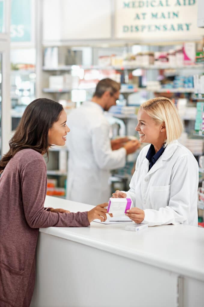 Pharmacist assisting customer at pharmacy counter