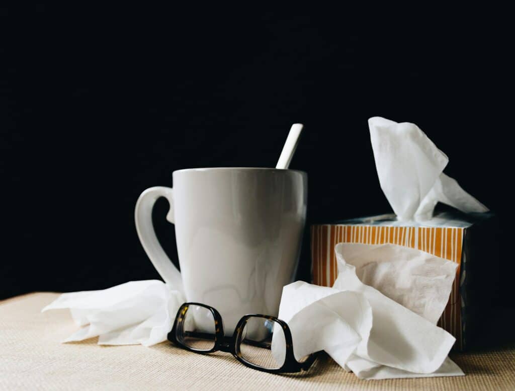 Mug, glasses, tissues on table.